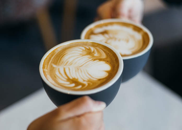 two cups of coffee with latte milk patterns on top