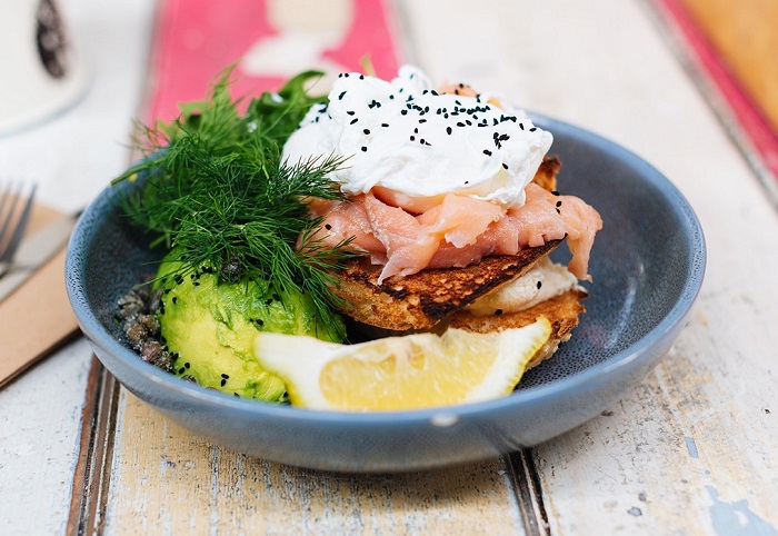 A bowl with food including salmon, egg and dill