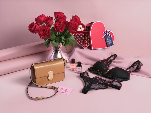A variety of valentines gifts including a red rose bouquet and some lingerie