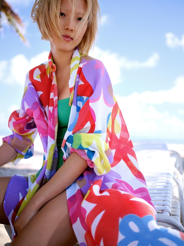 A model wearing a colourful printed beach shirt